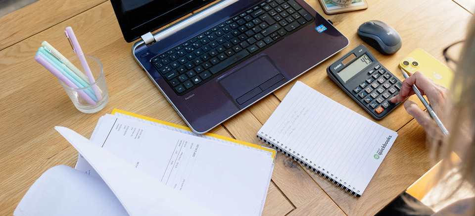 Caroline working at her desk with a laptop and papers